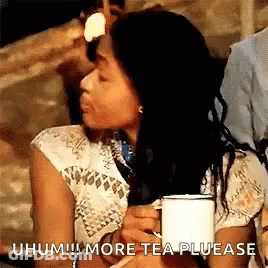 Woman Sitting At Table Holding Tea Making Funny Face GIF