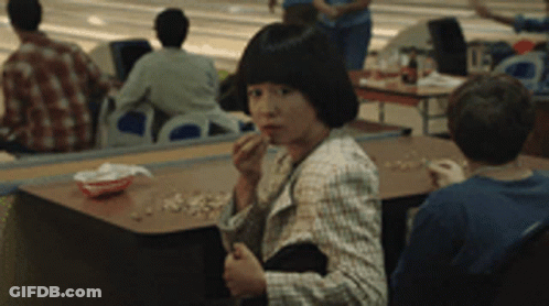Woman Sitting At Table In Bowling Alley GIF