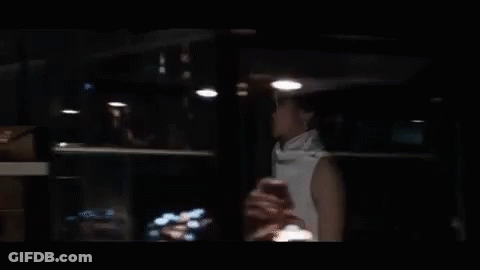 Woman Sitting At Table In Dark Room GIF