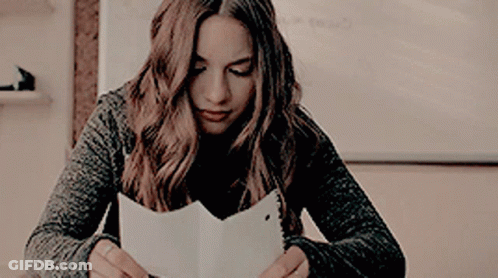 Woman Sitting At Table Reading A Book GIF
