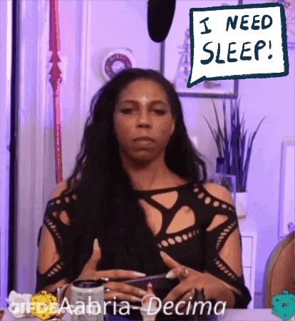 Woman Sitting At Table Saying I Need Sleep GIF