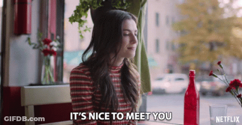Woman Sitting At Table Saying It's Nice To Meet You In Netflix Ad GIF