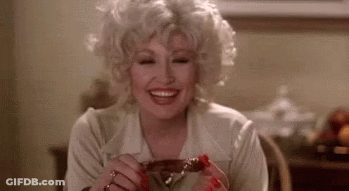 Woman Sitting At Table Smiling Holding Meat GIF