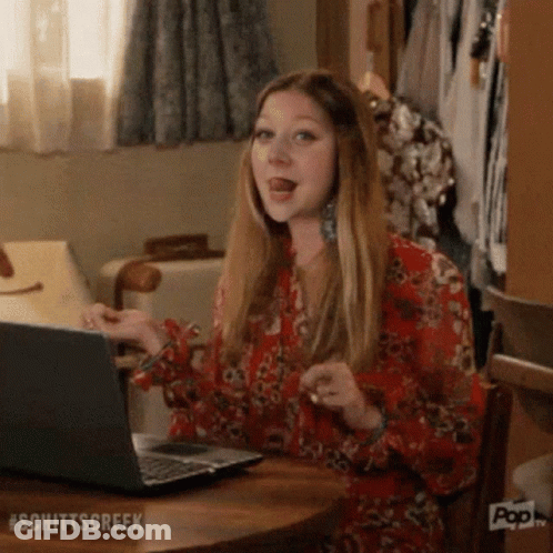 Woman Sitting At Table Using Laptop GIF