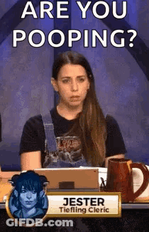 Woman Sitting At Table With Are You Pooping Sign GIF