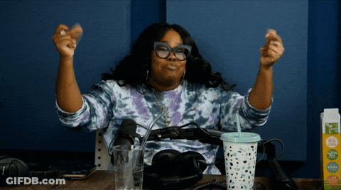 Woman Sitting At Table With Arms Up Next To Tropicana Carton GIF