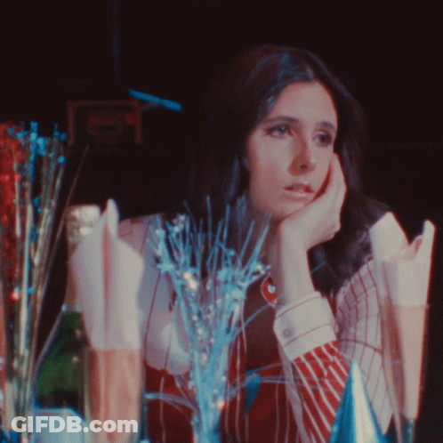 Woman Sitting At Table With Champagne And Decorations GIF