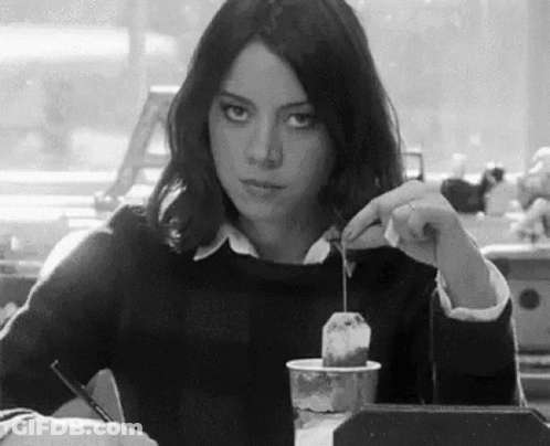 Woman Sitting At Table With Coffee And Tea Bag GIF