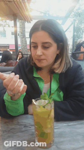 Woman Sitting At Table With Drink GIF