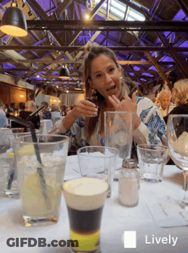 Woman Sitting At Table With Drinks GIF