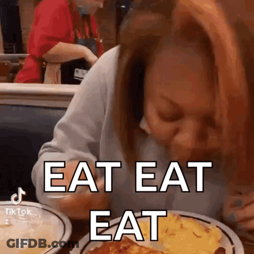Woman Sitting At Table With Eat Eat Eat GIF