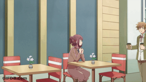 Woman Sitting At Table With Flowers In Vase GIF