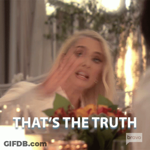 Woman Sitting At Table With Flowers Says That's The Truth GIF
