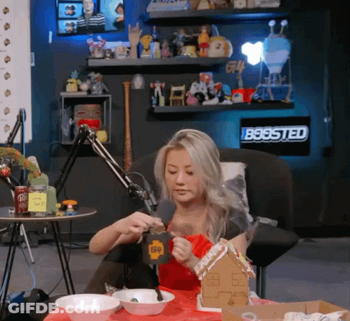 Woman Sitting At Table With Gingerbread House GIF