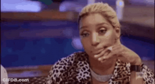 Woman Sitting At Table With Hand On Chin GIF