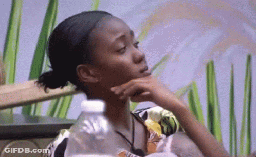 Woman Sitting At Table With Hand On Chin And Water Bottle GIF