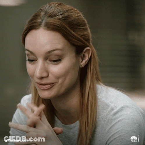 Woman Sitting At Table With Hands Folded Smiling GIF