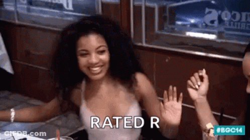 Woman Sitting At Table With Hands Up Rated R Sign GIF