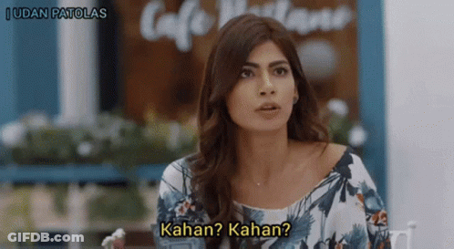 Woman Sitting At Table With Kahan Kahan Sign GIF