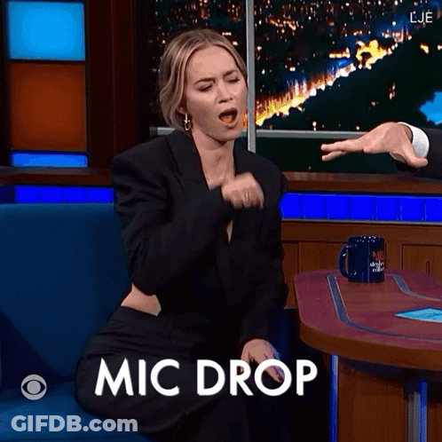Woman Sitting At Table With Mic Drop GIF