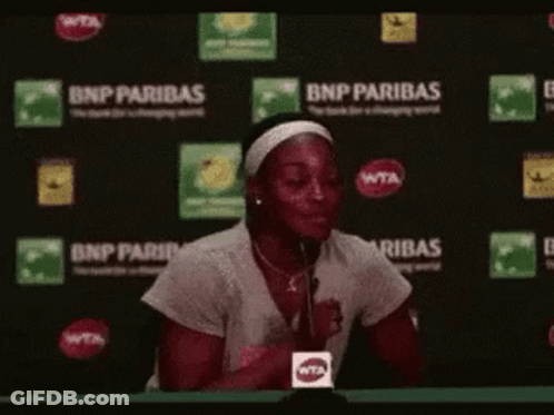 Woman Sitting At Table With Microphone GIF