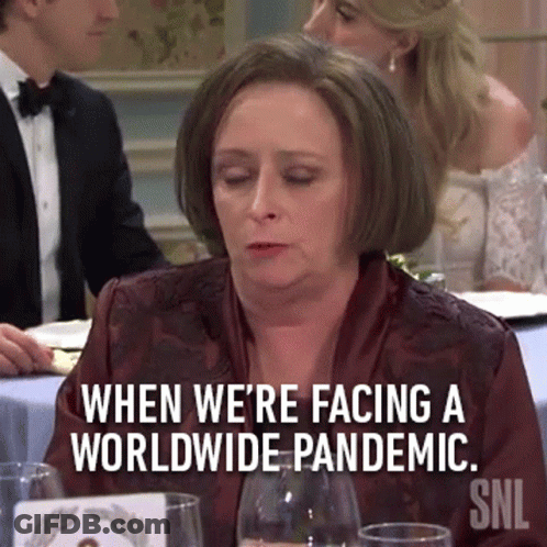 Woman Sitting At Table With Pandemic Sign GIF