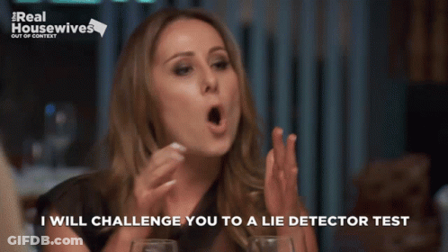 Woman Sitting At Table With Real Housewives Sign GIF
