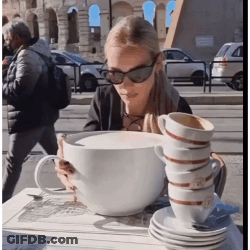 Woman Sitting At Table With Stack Of Coffee Cups GIF