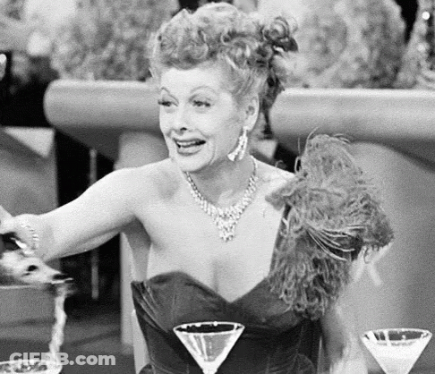 Woman Sitting At Table With Two Martinis GIF