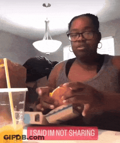 Woman Sitting Eating Hamburger Sign Saying Not Sharing GIF