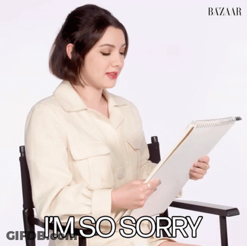 Woman Sitting Holding Sorry Paper GIF
