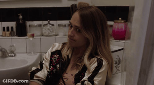 Woman Sitting In Bathroom Next To Sink GIF
