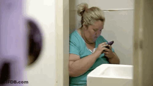 Woman Sitting In Bathroom Using Cell Phone GIF