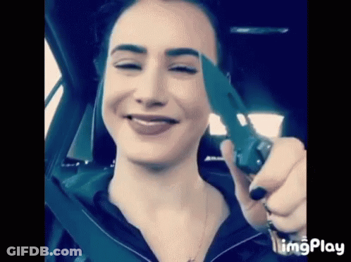 Woman Sitting In Car Holding Knife GIF