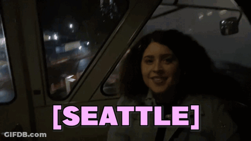 Woman Sitting In Car With Seattle On Screen GIF