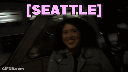 Woman Sitting In Car With Seattle On Screen GIF