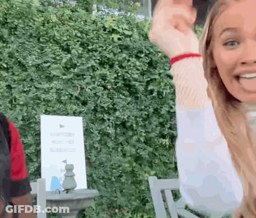 Woman Sitting In Chair Arms Up Sign Saying Right GIF
