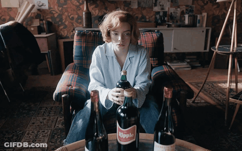 Woman Sitting In Chair Holding Bottle Of Hippie GIF