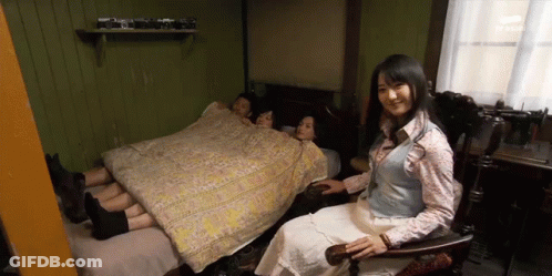Woman Sitting In Chair In Front Of Bed GIF