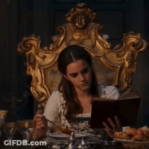 Woman Sitting In Chair Reading And Eating GIF