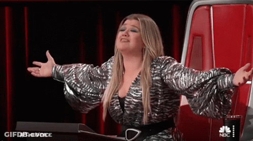 Woman Sitting In Chair With Arms Outstretched On Stage GIF