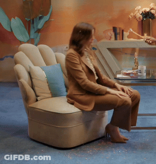 Woman Sitting In Chair With Blue Pillow GIF