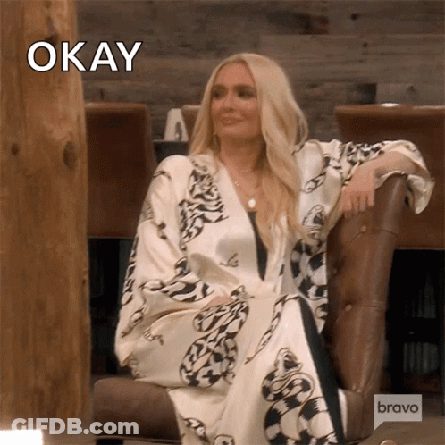 Woman Sitting In Chair With Word Okay Above Head GIF