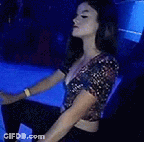 Woman Sitting In Club Holding Glass Of Wine GIF