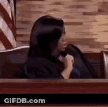Woman Sitting In Courtroom Holding Microphone GIF
