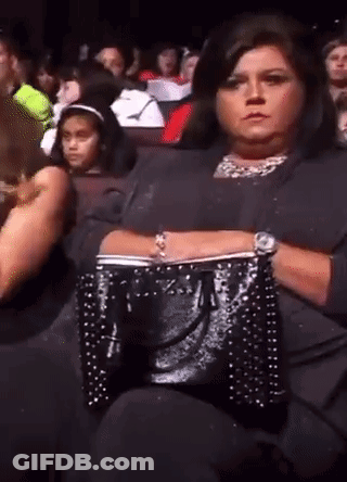 Woman Sitting In Crowd Watching Performance GIF
