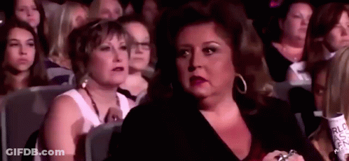 Woman Sitting In Crowd Watching Performance GIF