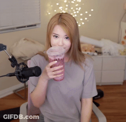 Woman Sitting In Front Of A Microphone Holding A Cup GIF