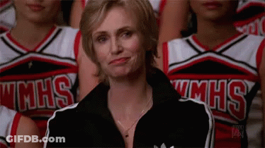 Woman Sitting In Front Of Cheerleaders In MHS Uniforms GIF