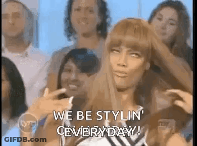 Woman Sitting In Front Of Crowd With Hair In Hand GIF